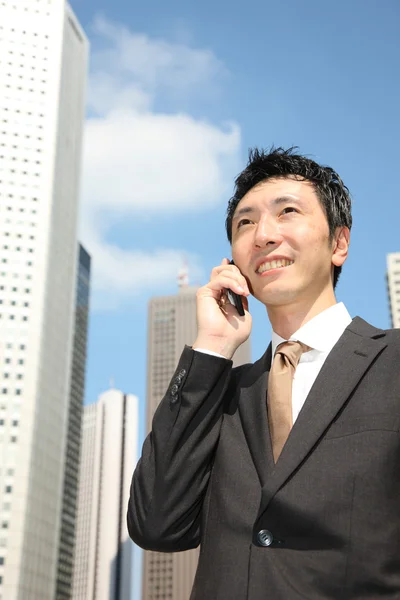 日本のビジネスマンは、モバイル フォンと協議します。 — ストック写真