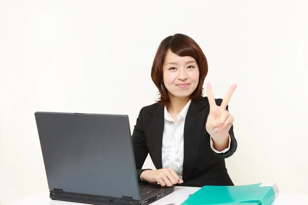 Japanse zakenvrouw tonen een teken van de overwinning — Stockfoto