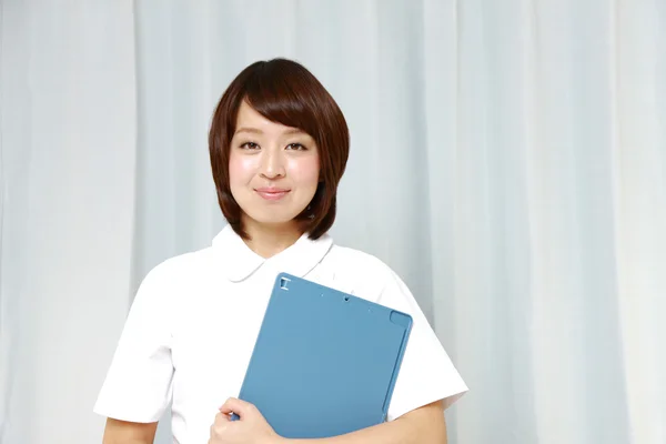 Young Japanese nurse with medical chart — Stock Photo, Image