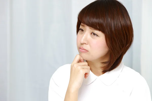 Japanese nurse thinks about something — Stock Photo, Image