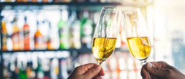 Barda şampanya bardaklarını tokuşturan iki kişi..