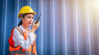 Konteynırın önünde telsiz kullanarak üniformalı genç Asyalı kadın mühendis portresi. Lojistik ve nakliye. Mesleki meslek.