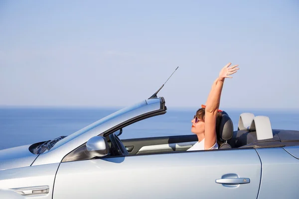 Junge Frau fährt Auto am Strand. — Stockfoto