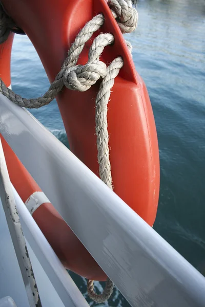 Röd livboj med rep på båt. — Stockfoto