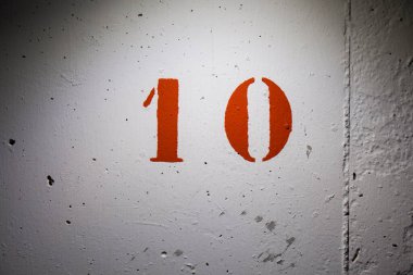 10 numara beyaz beton duvarda kırmızıya boyanmış.