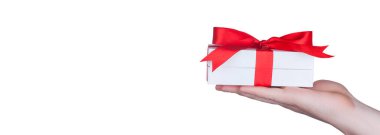 Saten kurdeleyle paketlenmiş bir hediye kutusu. Mutlu Noeller..