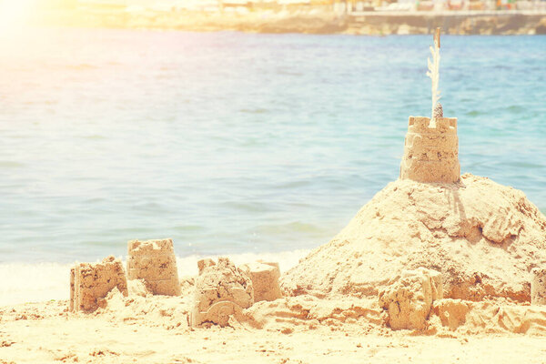 Holiday concept with sandcastle on the seaside.
