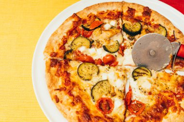 tavuk ve kiraz domates ve ekşi hamurlu sebzeli pizza ve beyaz tabakta çıtır altın kabuk ve metin kopyalamak ve yapıştırmak için yeri olan sarı masa örtüsü..