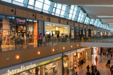 Dünyanın en ünlü markaları olan Levi 's, Stradivarius, Apple, Pull & Bear ve Zaragoza' daki Puerto Venecia alışveriş merkezinin içinde uzun süre gezen insanlar. 31 Temmuz 2021, ZARAGOZA, İspanya