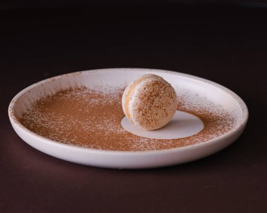 macarons isolat , macarons on a plate . on dark background upside backside  flowers and woman's hands 