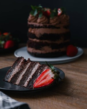 Masanın üzerinde bir dilim ev yapımı çikolatalı pasta.