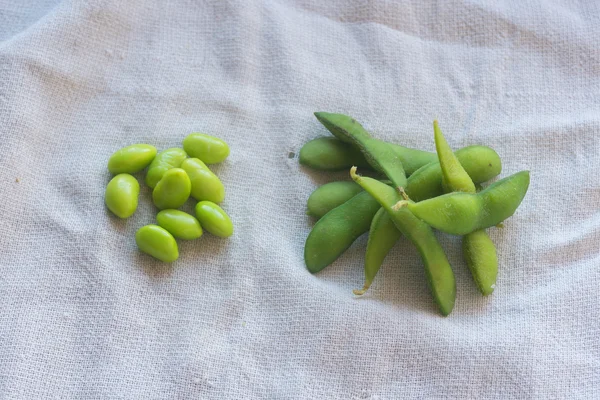 Boiled green soybeans on fabric background — Stock Photo, Image