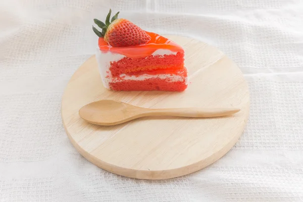 Piece of strawberry cake and half strawberry topping on white fabric — Stock Photo, Image