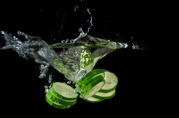 Sliced cucumber splashing water — Stock Photo, Image