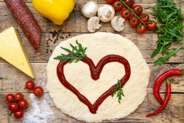 Pizza yapmak için malzemeler, pişirmeden önce, ahşap bir masa üzerinde, üst görünüm, adım adım tarif