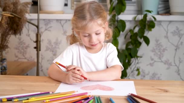 Uma Menina Entusiasticamente Desenha Coração Com Lápis Cor Sentado Mesa — Vídeo de Stock