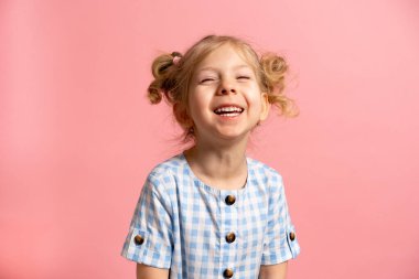 Pembe izole edilmiş küçük sarışın bir kız tatlı bir gülümsemesi var..