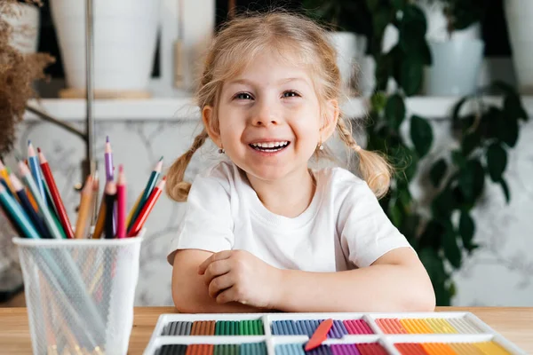 Ένα Μικρό Ξανθό Κορίτσι Ένα Γοητευτικό Χαμόγελο Κάθεται Ένα Τραπέζι — Φωτογραφία Αρχείου