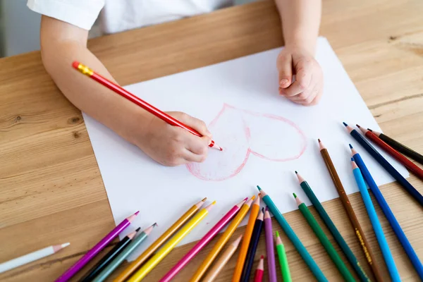 Little girl draws a red heart — Stock Photo, Image