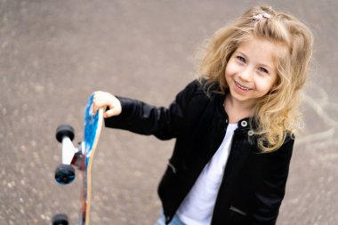 Şehirde kaykaylı küçük sarışın kız.. 