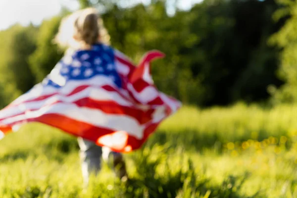 太陽の下で自然の中でアメリカ国旗を掲揚する美しいブロンドの女の子 — ストック写真