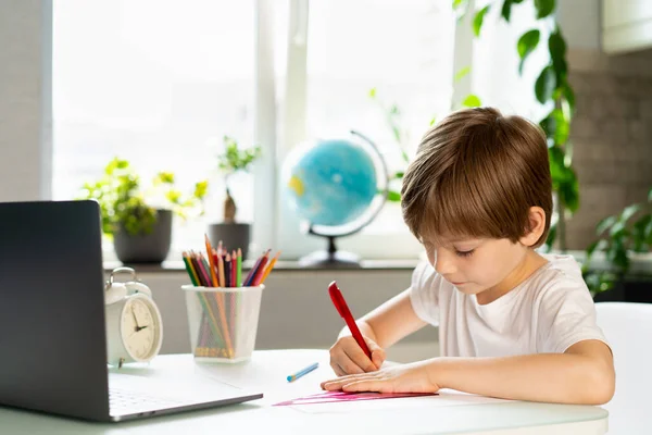 Μικρό Αγόρι Κάνει Μαθήματα Στο Σπίτι Στο Τραπέζι Μπροστά Από — Φωτογραφία Αρχείου