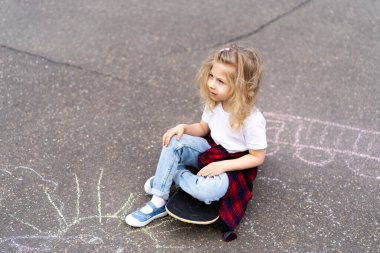 Şehirde kaykaylı küçük sarışın kız.. 