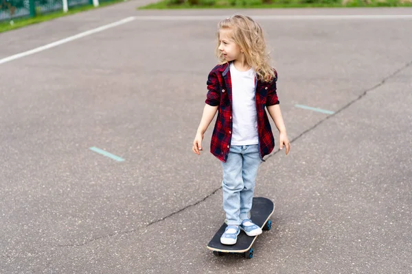 Şehirde kaykaylı küçük sarışın kız.. 