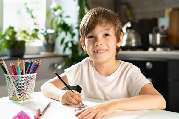Το μικρό αγόρι κάνει μαθήματα στο σπίτι στο τραπέζι, εξ αποστάσεως εκπαίδευση online εκπαίδευση. — Φωτογραφία Αρχείου