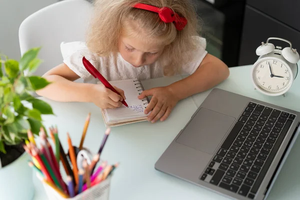 Μικρό Κορίτσι Κάνει Μαθήματα Στο Σπίτι Ένα Φορητό Υπολογιστή Γράφει — Φωτογραφία Αρχείου