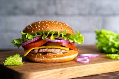 Tahtada hamburgerli, domatesli, peynirli ve marullu..
