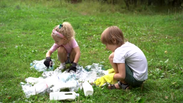 Dzieci usuwają plastikowe śmieci i umieszczają je w biodegradowalnym worku na świeżym powietrzu. Koncepcja ekologii, przetwarzania odpadów i ochrony przyrody. Ochrona środowiska — Wideo stockowe