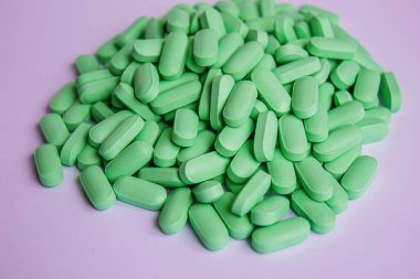 Beslenme takviyesi olarak kullanılan vitamin hapları. Yeşil haplar. Seçici odaklanma.