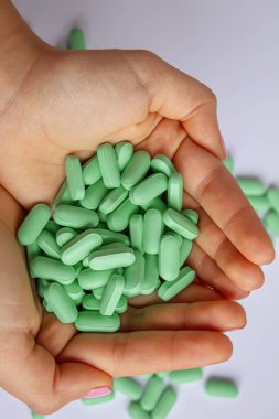Beslenme takviyesi olarak kullanılan vitamin hapları. Yeşil haplar. Seçici odaklanma.