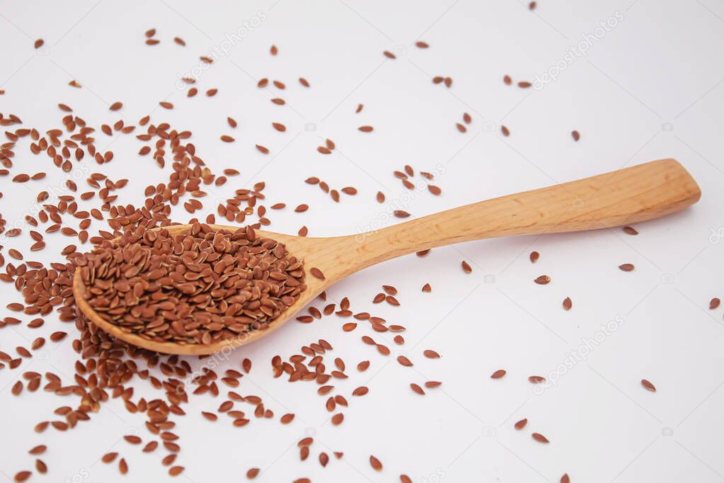 Flax seeds on a white background close-up of flax seeds in a wooden spoon.selectiv focus.food