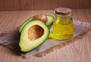 Ahşap arka planda avokado ve avokado yağı. Seçici odaklanma. Yemek