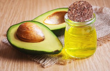 Ahşap arka planda avokado ve avokado yağı. Seçici odaklanma. Yemek