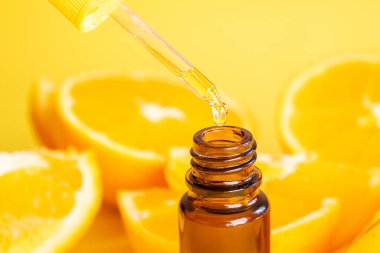 Sarı arka planda turuncu esanslı yağ. Seçici odaklanma. Doğa.