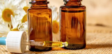 Papatya çayı, küçük bir şişe içinde yağmalama. Seçici odaklanma. Doğa 