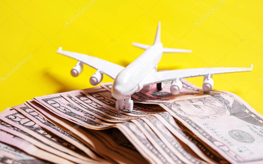 Travel preparation concept of airplane, money, passport, on yellow background. Selective focus.holidays