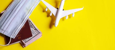 Seyahat hazırlama konsepti uçak, para, pasaport, sarı arka plan. Seçici odaklanma. Tatiller