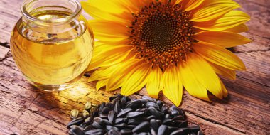 Eski ahşap arka planda ayçekirdeği ve yağ şişesi. Seçici odaklanma. Doğa.