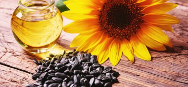 Eski ahşap arka planda ayçekirdeği ve yağ şişesi. Seçici odaklanma. Doğa.