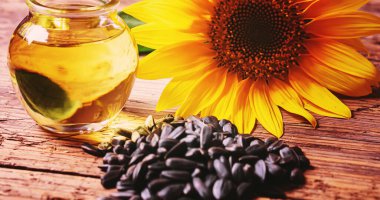 Eski ahşap arka planda ayçekirdeği ve yağ şişesi. Seçici odaklanma. Doğa.