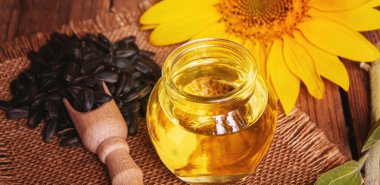 Eski ahşap arka planda ayçekirdeği ve yağ şişesi. Seçici odaklanma. Doğa.