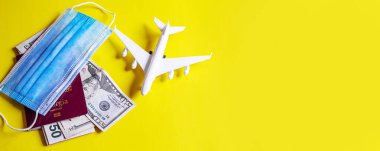 Seyahat hazırlama konsepti uçak, para, pasaport, sarı arka plan. Seçici odaklanma. Tatiller