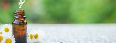 Papatya yağı küçük bir şişede. Seçici odaklanma. Doğa.