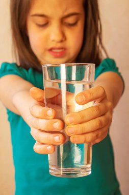 Çocuk elinde bir bardak su tutuyordu. Seçici odaklanma. Doğa