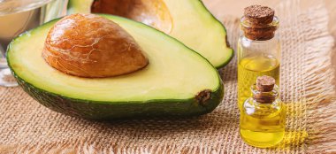 Ahşap arka planda avokado ve avokado yağı. Seçici odaklanma. Yemek