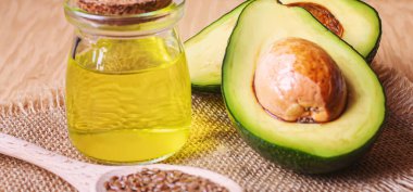 Ahşap arka planda avokado ve avokado yağı. Seçici odaklanma. Yemek